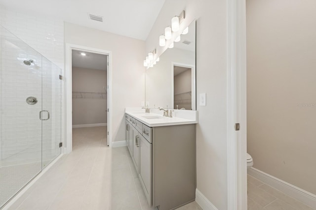 bathroom with toilet, vanity, visible vents, a spacious closet, and a shower stall