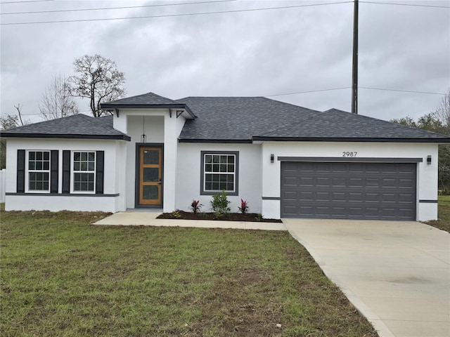 view of front of house featuring a front yard, roof with shingles, driveway, and an attached garage