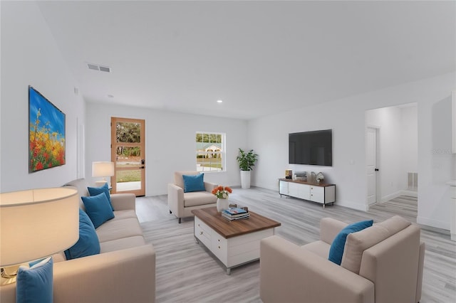 living room featuring baseboards, visible vents, and light wood-style floors