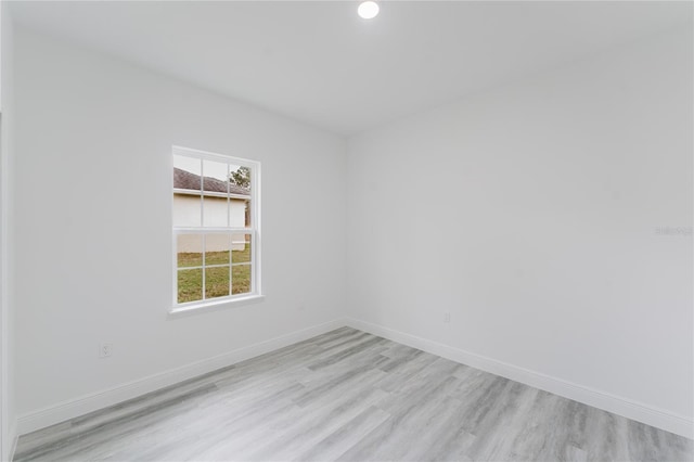 spare room with light wood-type flooring and baseboards