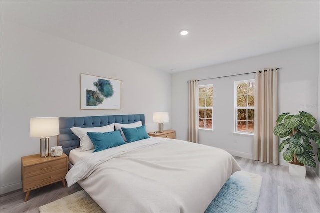 bedroom with recessed lighting, light wood-type flooring, and baseboards