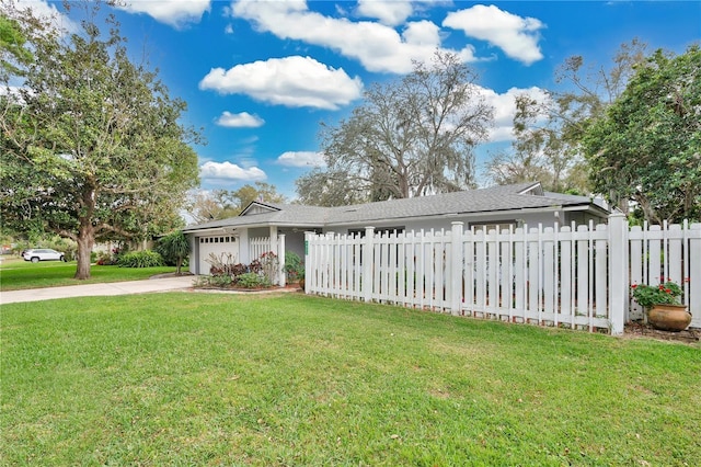 ranch-style house with a garage, a front yard, concrete driveway, and a fenced front yard