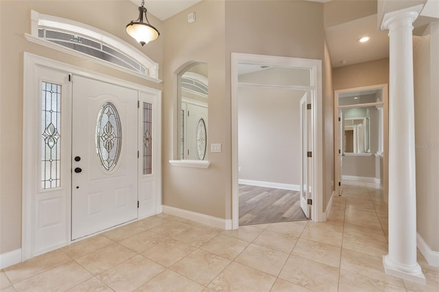 foyer entrance with ornate columns, light tile patterned floors, baseboards, and recessed lighting