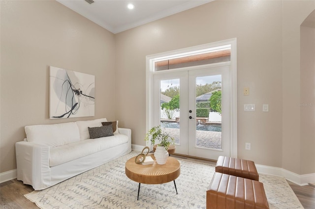 living area featuring recessed lighting, wood finished floors, baseboards, ornamental molding, and french doors