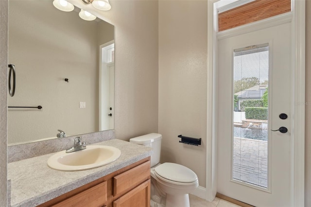 half bath featuring tile patterned flooring, vanity, and toilet