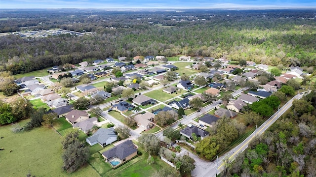 drone / aerial view featuring a residential view and a view of trees