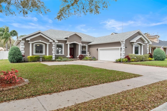 ranch-style home with a garage, concrete driveway, a front yard, and stucco siding