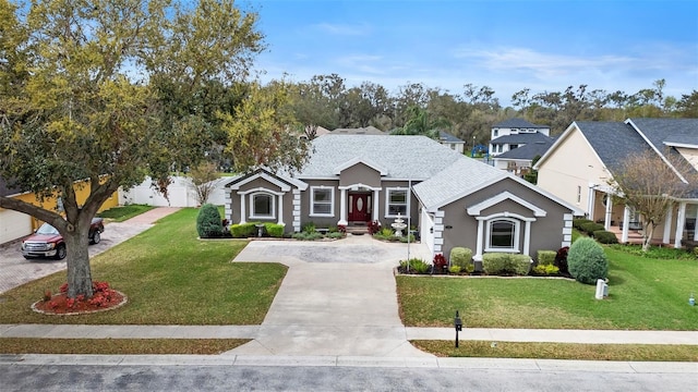 view of front of property featuring driveway, a front lawn, and roof with shingles