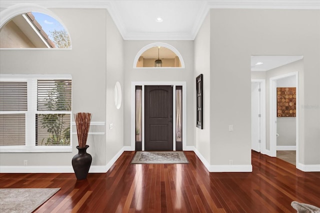 entryway with dark wood-style flooring, a high ceiling, crown molding, and baseboards