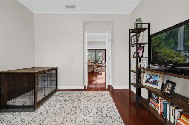 interior space featuring baseboards, wood finished floors, and crown molding