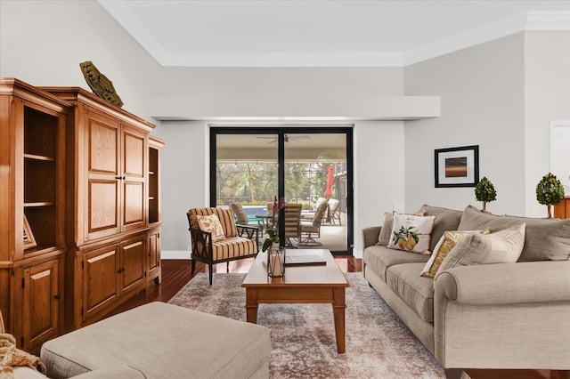 living room with ornamental molding, baseboards, and wood finished floors