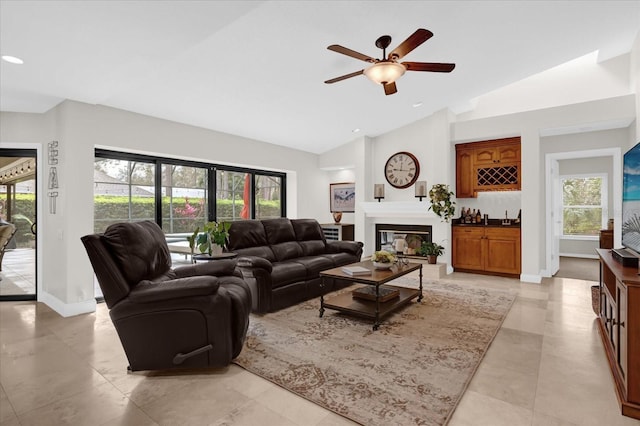 living room with indoor wet bar, recessed lighting, a glass covered fireplace, ceiling fan, and baseboards