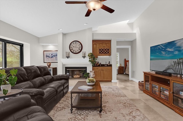 living room featuring light tile patterned floors, baseboards, a ceiling fan, vaulted ceiling, and a fireplace