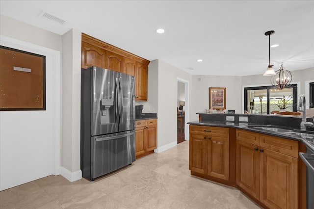 kitchen with stainless steel appliances, a sink, visible vents, and brown cabinets