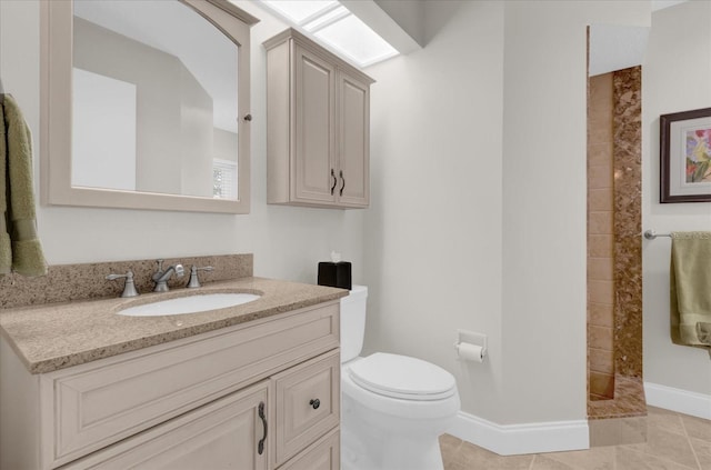 bathroom with baseboards, toilet, tile patterned flooring, vanity, and a walk in shower