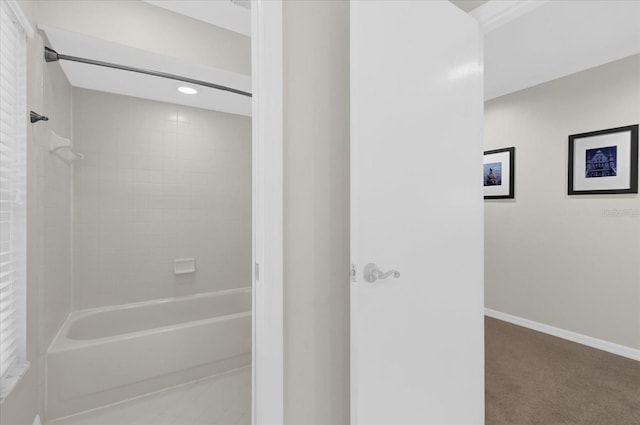 bathroom featuring tub / shower combination and baseboards