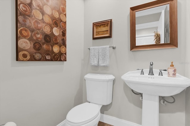 bathroom with toilet and baseboards