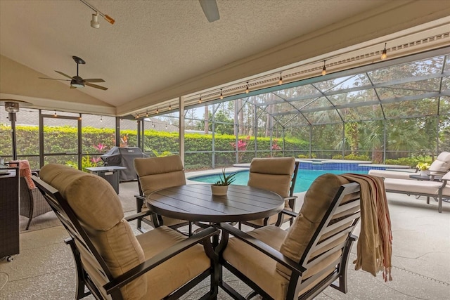 sunroom featuring vaulted ceiling and a ceiling fan