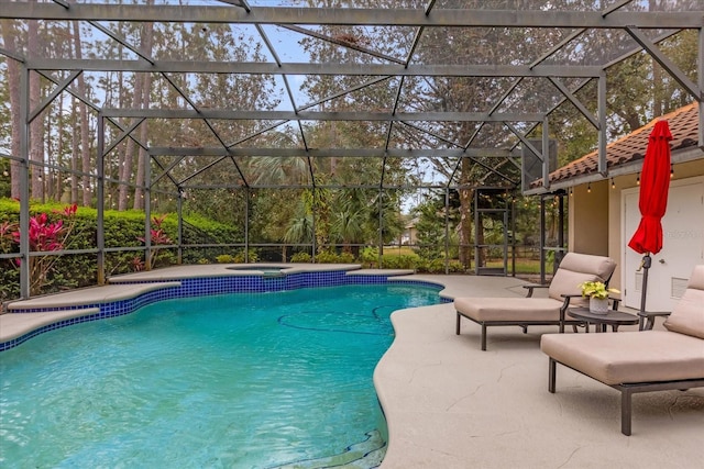 outdoor pool with glass enclosure, a patio, and an in ground hot tub