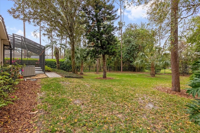 view of yard with a lanai and central AC unit