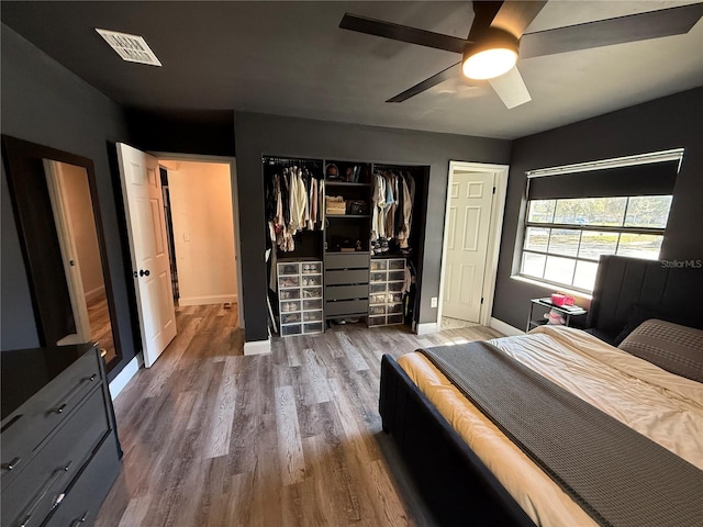 bedroom featuring a closet, visible vents, baseboards, and wood finished floors