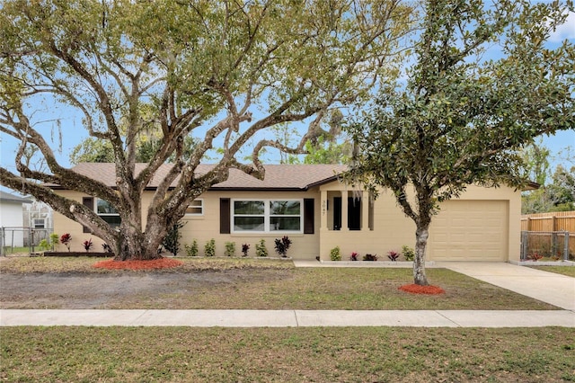 single story home with a garage, a shingled roof, concrete driveway, fence, and a front lawn