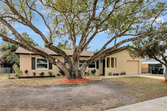 ranch-style home featuring driveway, a garage, a gate, and fence