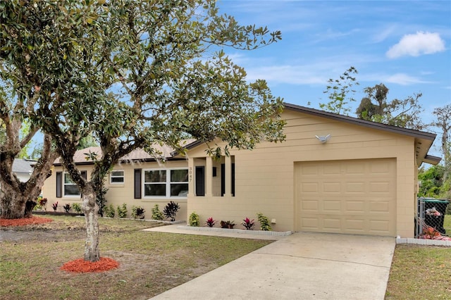 ranch-style home with concrete driveway, a front lawn, and an attached garage