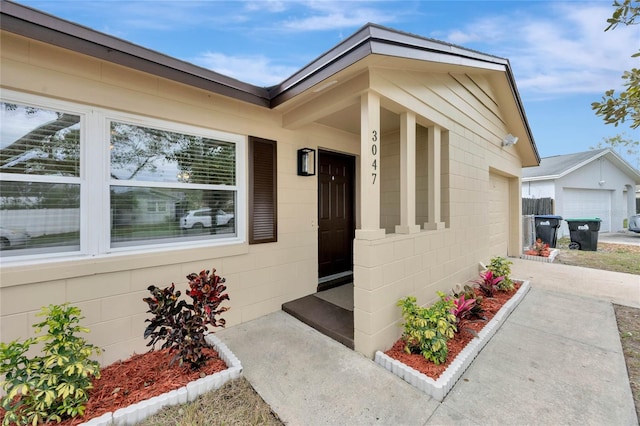 doorway to property featuring a garage and concrete block siding