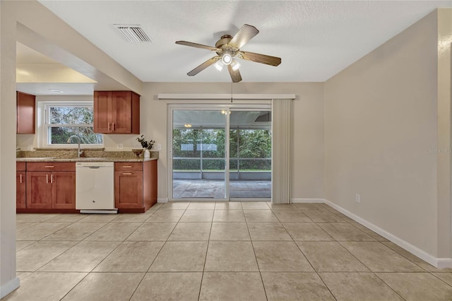 kitchen with baseboards, visible vents, light stone counters, and dishwasher