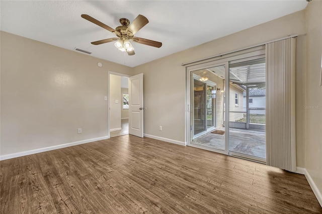 spare room with visible vents, baseboards, ceiling fan, and wood finished floors