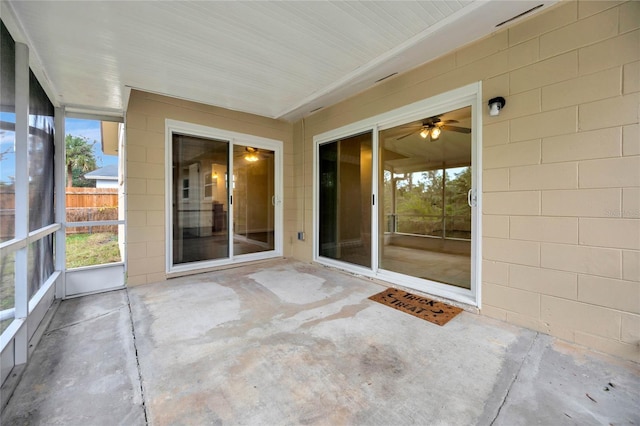 unfurnished sunroom featuring a ceiling fan