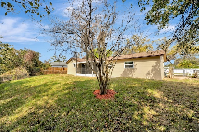 view of yard featuring a sunroom and a fenced backyard