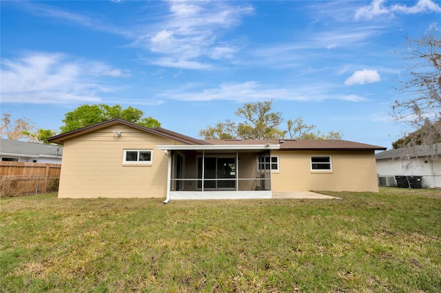 rear view of property featuring a sunroom, fence, and a yard