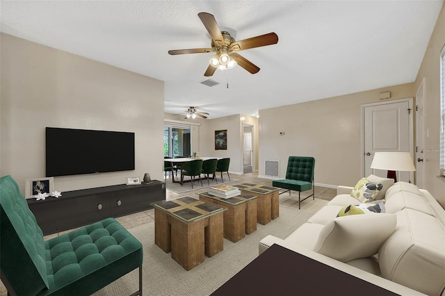 living room featuring ceiling fan, visible vents, and baseboards