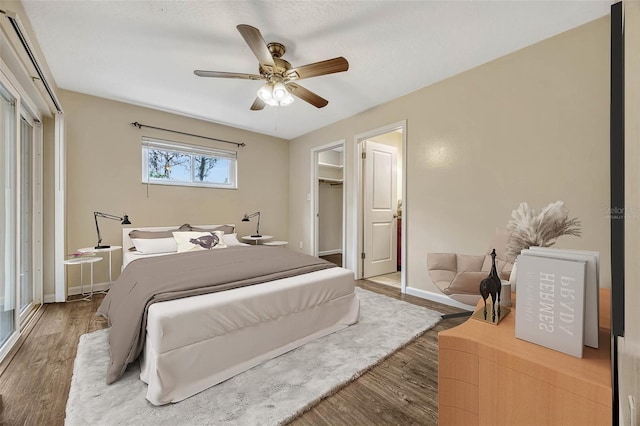 bedroom featuring light wood-style floors, ceiling fan, baseboards, and a closet