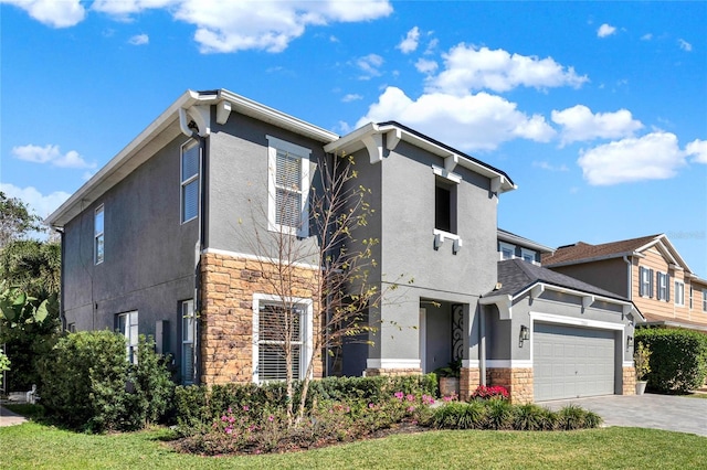 view of front of property featuring stone siding, an attached garage, decorative driveway, a front lawn, and stucco siding