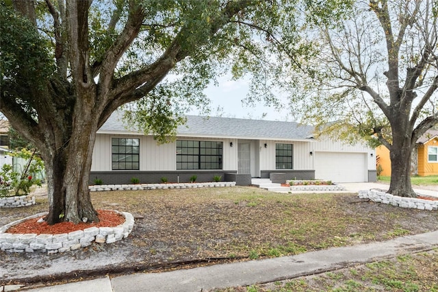 view of front facade featuring driveway, an attached garage, a shingled roof, and brick siding