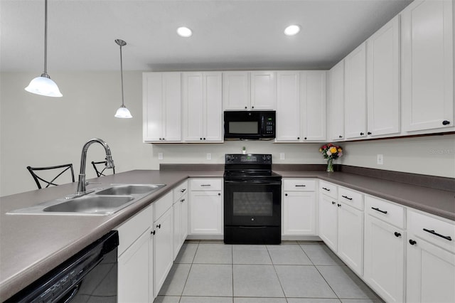 kitchen featuring white cabinets, dark countertops, black appliances, pendant lighting, and a sink