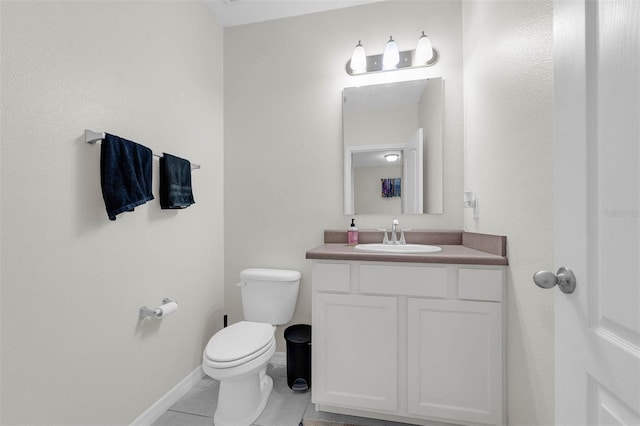 bathroom featuring vanity, tile patterned flooring, toilet, and baseboards