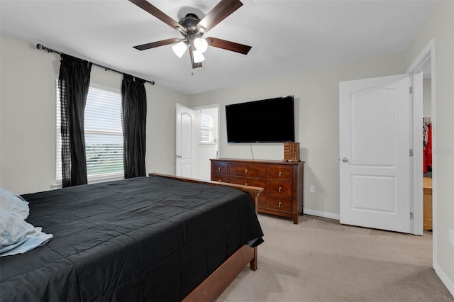 bedroom with baseboards, a ceiling fan, and light colored carpet