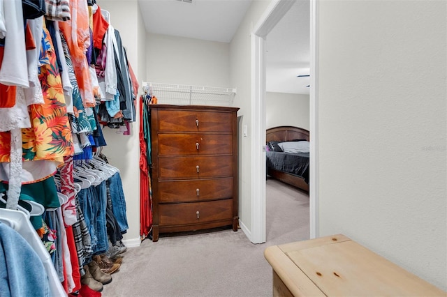 walk in closet featuring light colored carpet