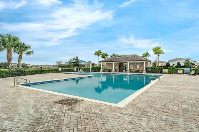 pool with a patio area and fence