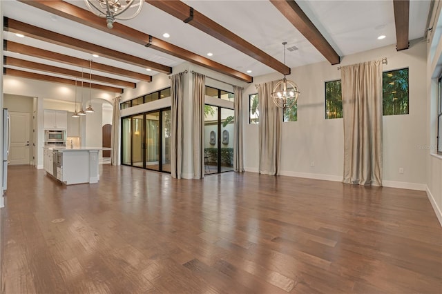 unfurnished living room featuring a notable chandelier, beamed ceiling, and dark wood-type flooring