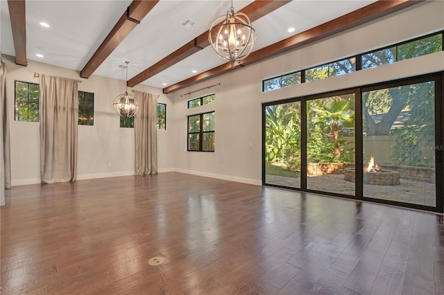 unfurnished room featuring a notable chandelier, beam ceiling, and dark hardwood / wood-style floors