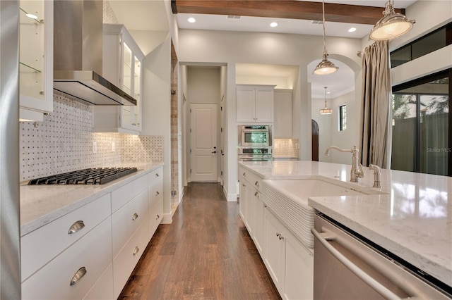 kitchen with white cabinetry, appliances with stainless steel finishes, and wall chimney range hood