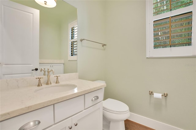 bathroom featuring hardwood / wood-style flooring, toilet, and vanity