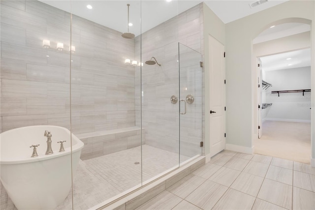 bathroom with separate shower and tub and tile patterned flooring