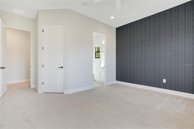 unfurnished bedroom with connected bathroom and light colored carpet