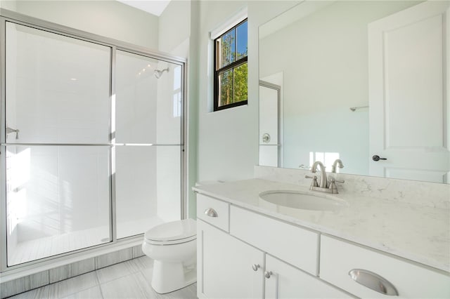 bathroom featuring tile patterned flooring, vanity, toilet, and walk in shower